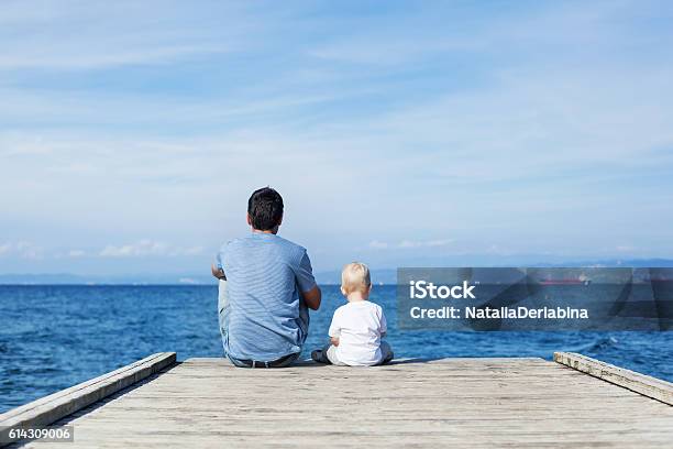 Foto de Pai Com O Filho Sentado No Cais Do Mar e mais fotos de stock de Pai - Pai, Mar, Filho