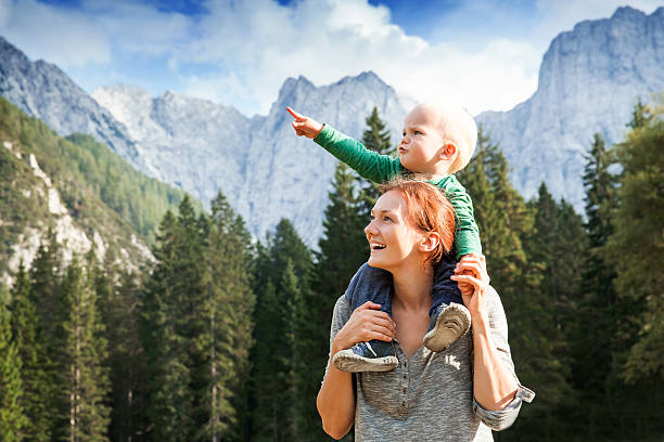 travel, explore, family, future concept - mother holding child pointing imagens e fotografias de stock