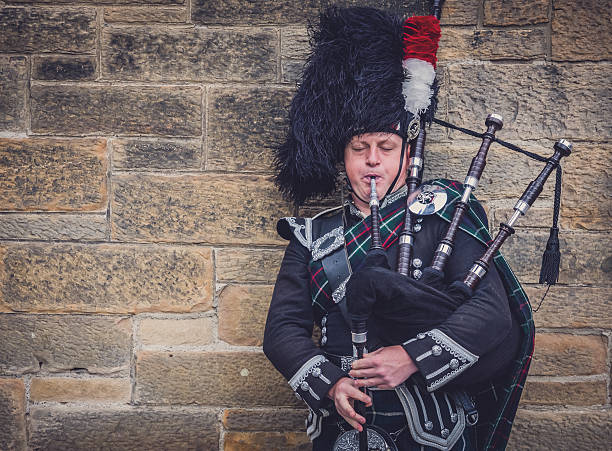 Edinburgh, Scotland - May 24, 2018: Man in traditional Scottish clothing playing bagpipe at the Royal Mile in Edinburgh