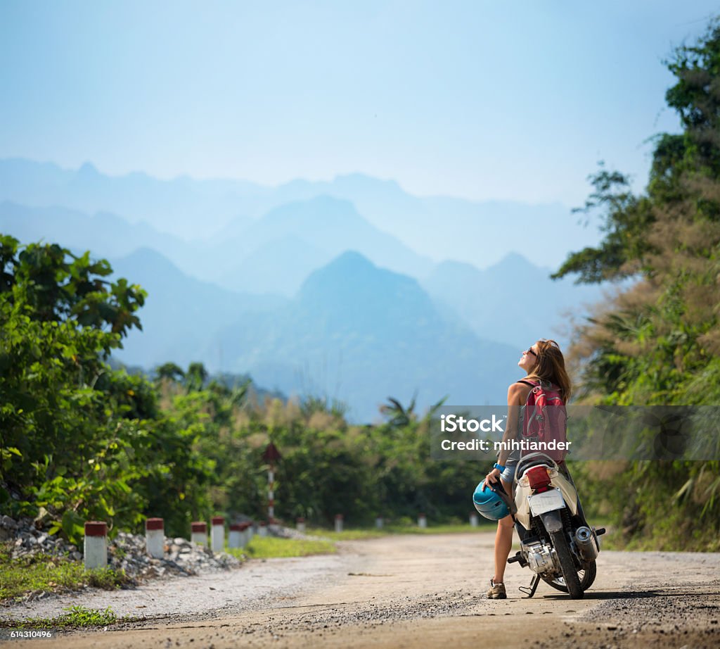 Young lady with bike Young lady sitting at motorbike and enjoying landscape view Motorcycle Stock Photo