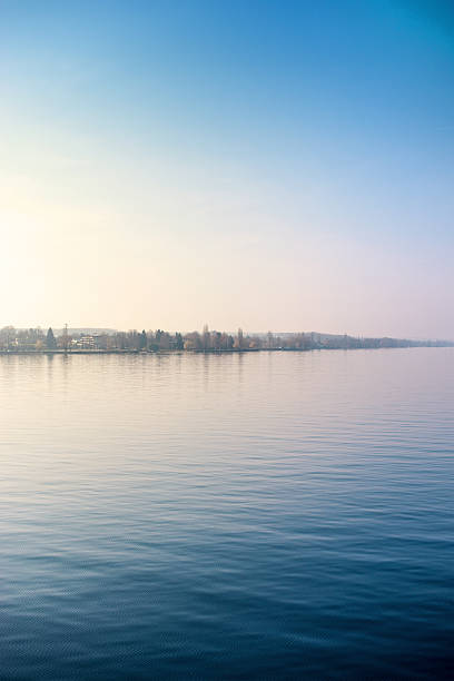 Headland with houses and parks in a cold sunrise. Horizon in the vertical middle of the image.