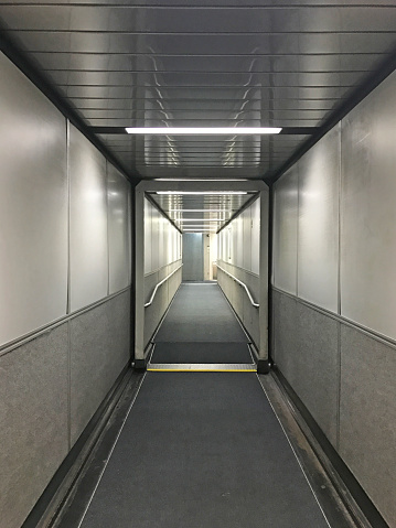 The interior of an airport jet bridge that links the main aiport to the entrance of the airplane.