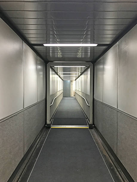 Airport Jet Bridge The interior of an airport jet bridge that links the main aiport to the entrance of the airplane. passenger boarding bridge stock pictures, royalty-free photos & images