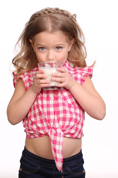 istock Little girl drinking milk. Close up. White background 614314704