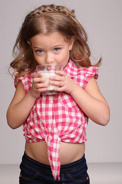 istock Baby licking milk. Close up. Gray background 614314736