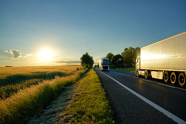 istock Trucks moving against each other on the road at sunset. 614316238