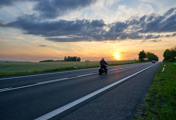 istock Motion blur motorcycle riding on the asphalt road at sunset. 614316342