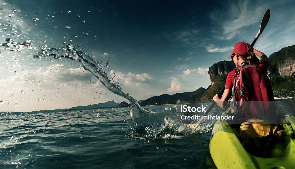 Woman with the kayak Young lady paddling hard the sea kayak with lots of splashes Activity Stock Photo