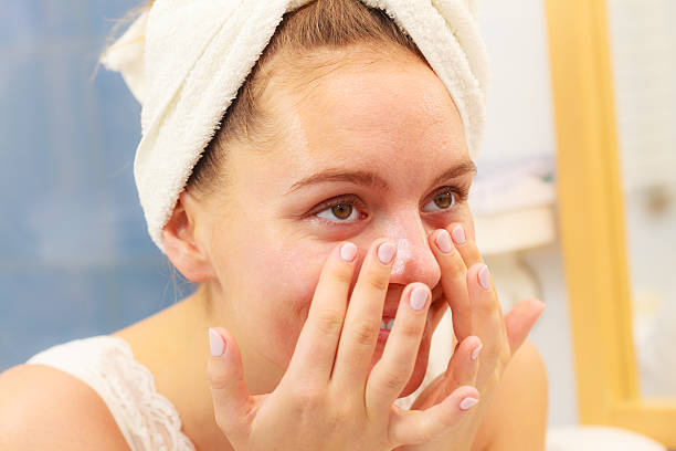 istock Woman applying mask cream on face in bathroom 614318148