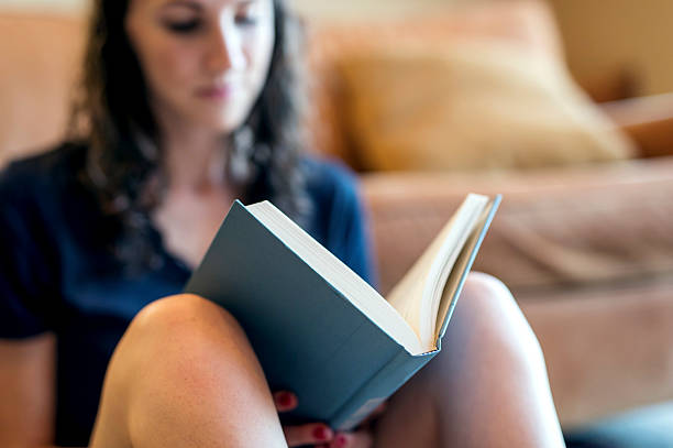 istock Adult female relaxing and reading a book 614321552