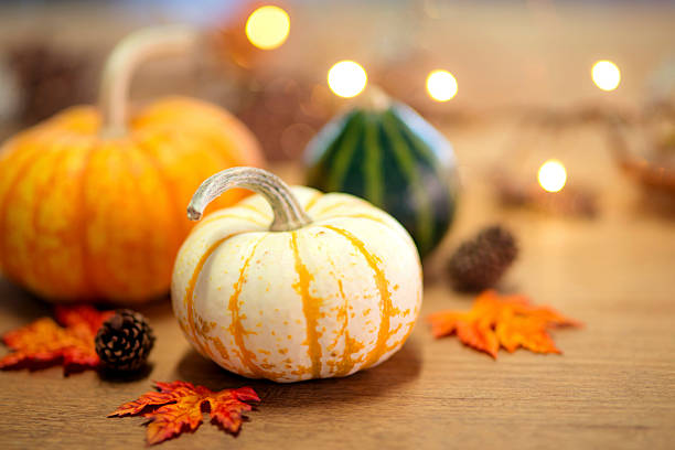 istock White speckled pumpkin sitting on a wooden table 614323856