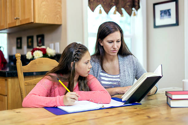 istock Mother and daughter doing homework together 614324642