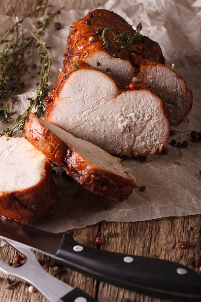 istock homemade sliced roasted turkey close-up on paper. Vertical 614325642