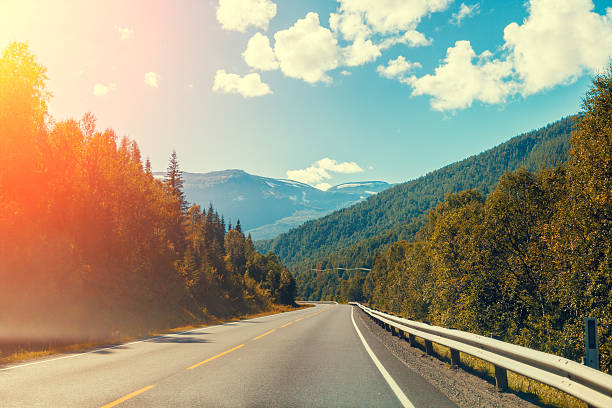 istock Mountain road at sunset with blue light cloudy sky 614325746