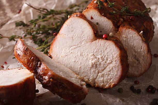 istock Delicious sliced roasted turkey close-up on paper. Horizontal 614325996