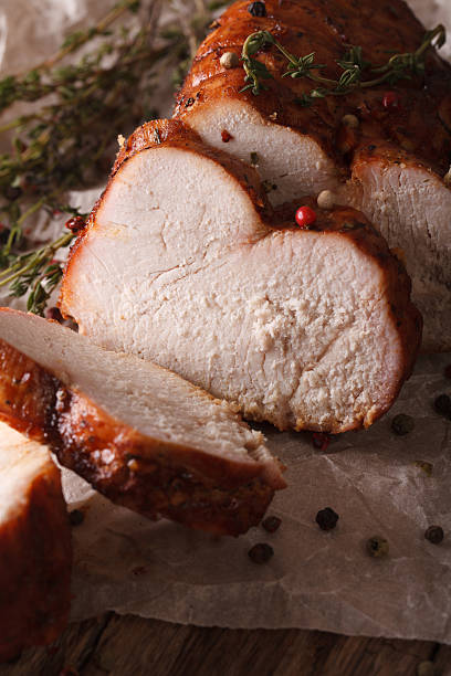 istock Delicious sliced roasted turkey close-up on paper. vertical 614326172