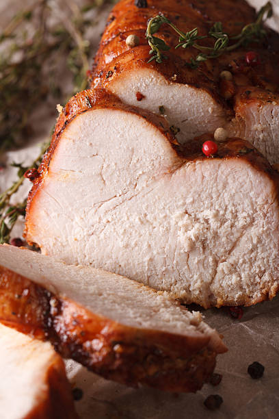 istock Roasted turkey fillet with thyme and spices macro. vertical 614326590