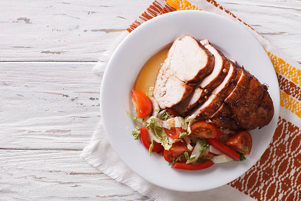 Sliced roasted turkey breast and fresh vegetables. Horizontal Sliced roasted turkey breast and fresh vegetables on the plate. Horizontal top view turkey breast stock pictures, royalty-free photos & images