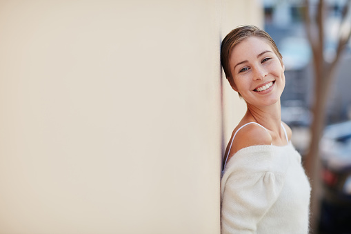 Portrait of a smiling young woman standing outside