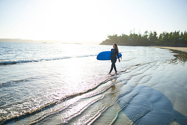 istock Strong beautiful young woman with surf on the beach 614327870