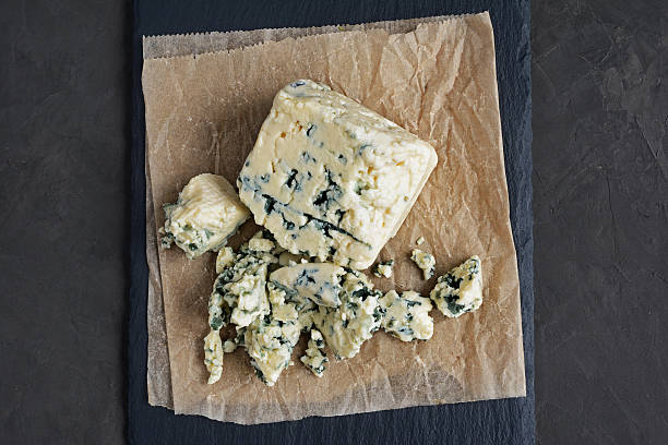 Delicious blue cheese Delicious blue cheese on black slate background roquefort cheese stock pictures, royalty-free photos & images
