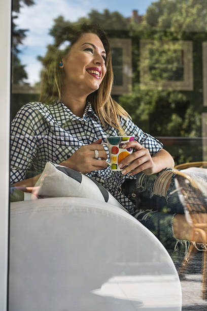 istock Young smiling woman enjoying in coffee time at home. 614328268