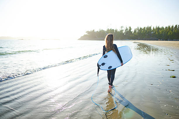istock Strong beautiful young woman with surf on the beach 614328664