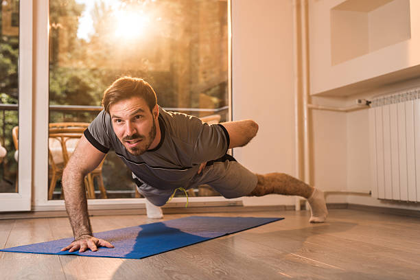 istock Young man exercising one hand push-ups at home. 614328720