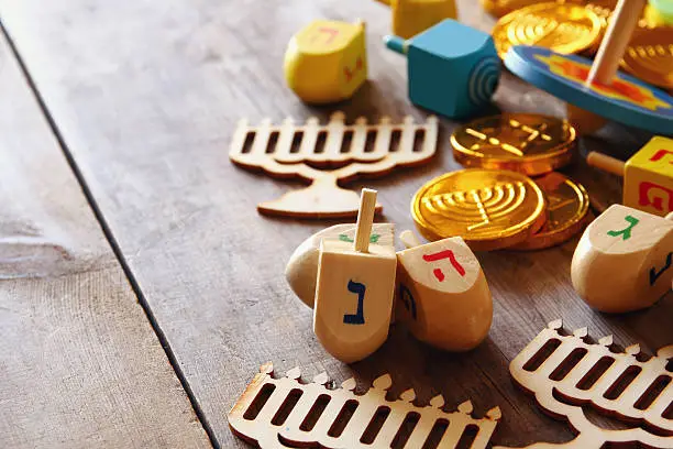 Image of jewish holiday Hanukkah with wooden dreidels colection (spinning top) and chocolate coins on the table