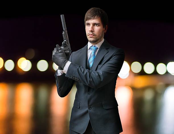 istock Killer holds pistol with silencer in hands at night. 614330296