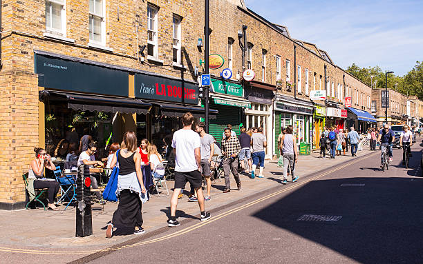 personas caminando frente a restaurantes locales en broadway market - london store fotografías e imágenes de stock