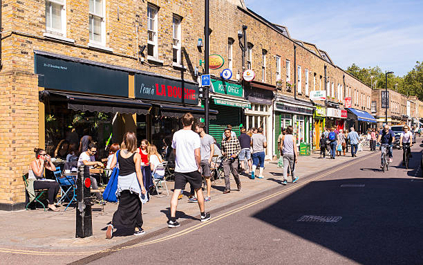 люди гуляют перед местными ресторанами на бродвейском рынке - retail london england uk people стоковые фото и изображения