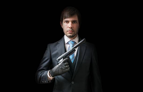 istock Hitman or murderer with pistol with silencer on black background 614330566