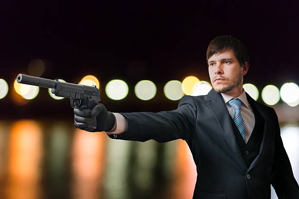 istock Agent or hitman is aiming with pistol with silencer. 614330680