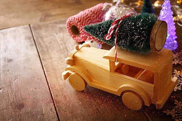 istock Wooden car carrying a christmas tree. Glitter overlay 614331146