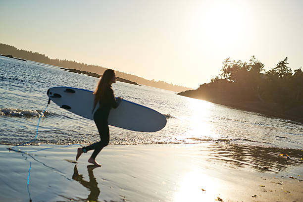 istock Strong beautiful young woman with surf on the beach 614331394
