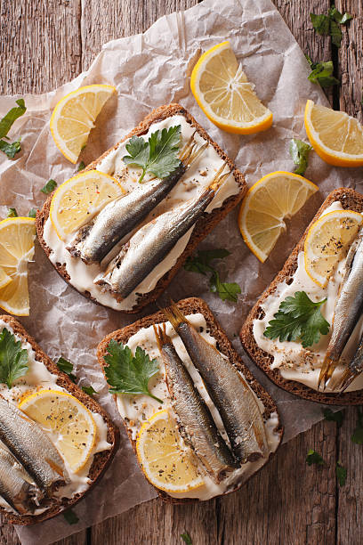 istock Sandwiches with sprats, cream cheese close-up. vertical top view 614331814