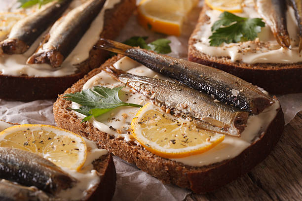 istock fish sandwiches with sprats, cream cheese and lemon macro. horizintal 614333032