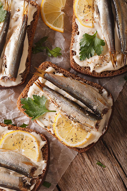 istock Sandwiches with sprats and cream cheese macro. vertical top view 614333708