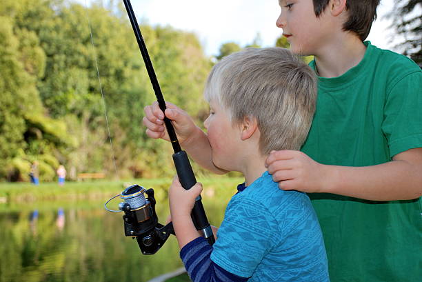 istock Big Boy helps little Brother to Fish 614333786
