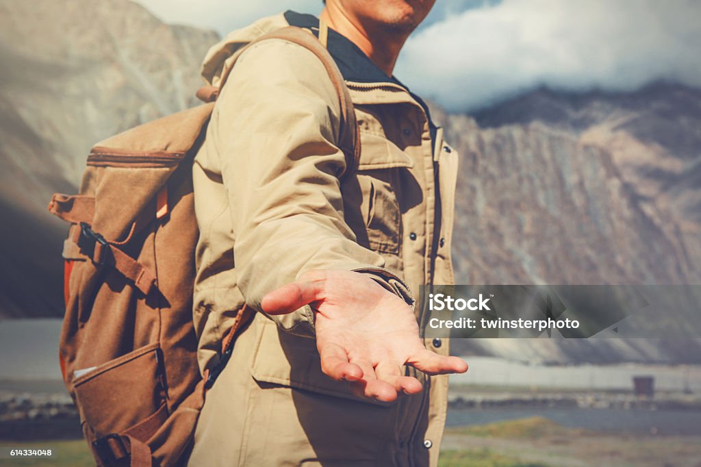 Jeune homme de voyage donnant un coup de main dans la montagne - Photo de Guide libre de droits