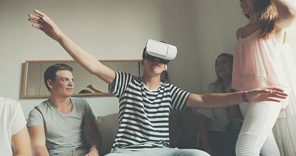istock Man wearing VR virtual reality headset with friends 614334196