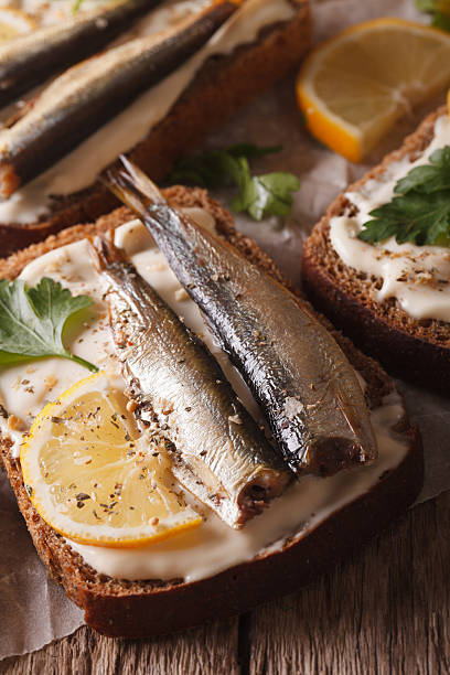 istock fish Sandwiches with sprats and cream cheese close-up. vertical 614334386