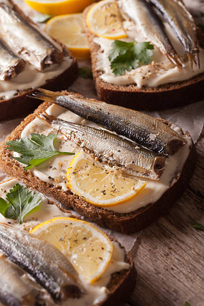 istock Sandwiches with sprats and cream cheese close-up. vertical 614334720