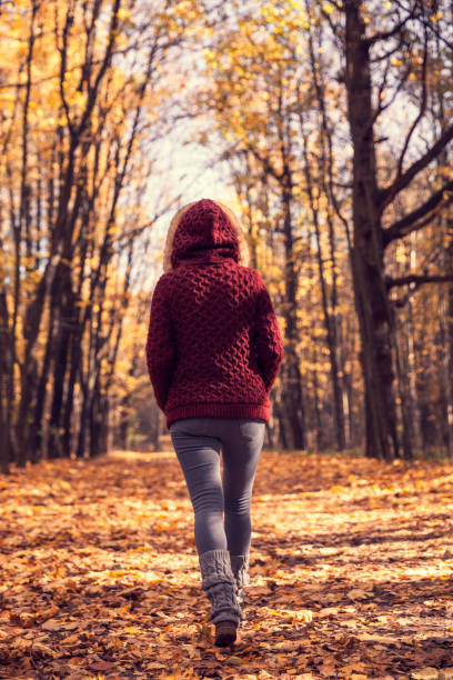 istock Woman in autumn park 614335260