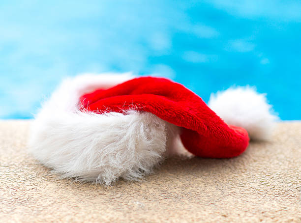 istock Red christmas hat near the pool. 614336928