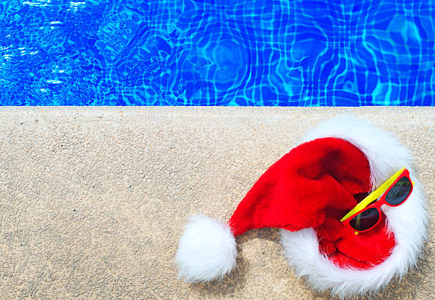 istock Red christmas hat and sunglasses near the pool. 614337596