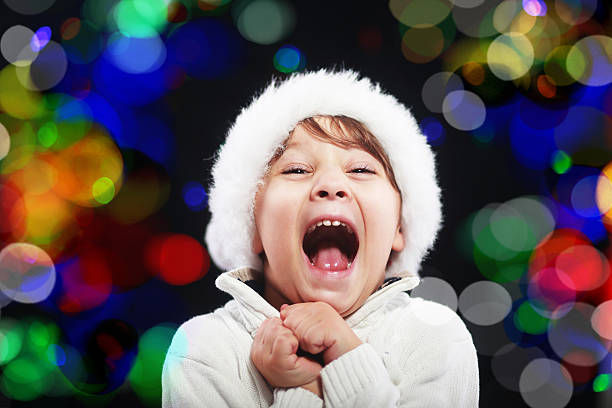 amazing christmas concept happy little boy screaming from the amazing christmas concept santa hat bokeh light at background christmas excitement stock pictures, royalty-free photos & images