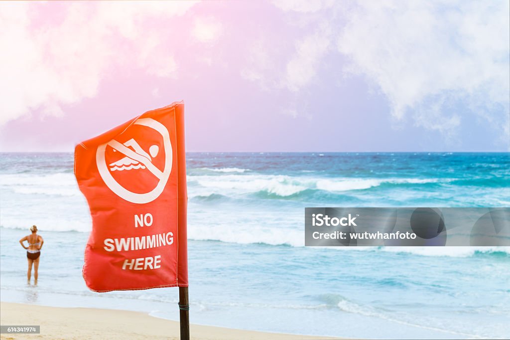 No swimming danger sign at the beach, No swimming danger sign at the beach, warning sign at the beach with people swim, caution no swimming allowed. Beach Stock Photo