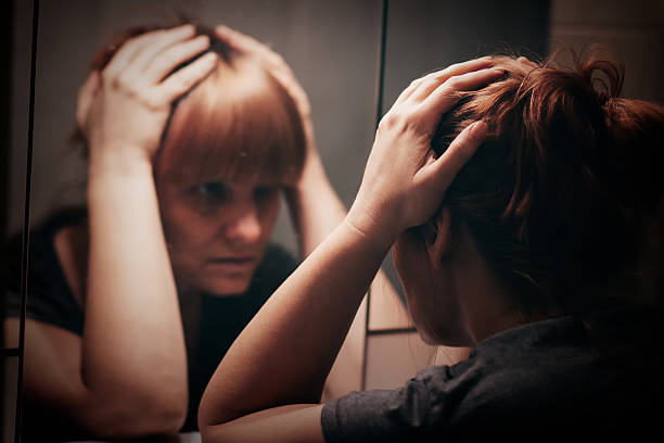 istock Sad and lonely woman holding her head 614342688